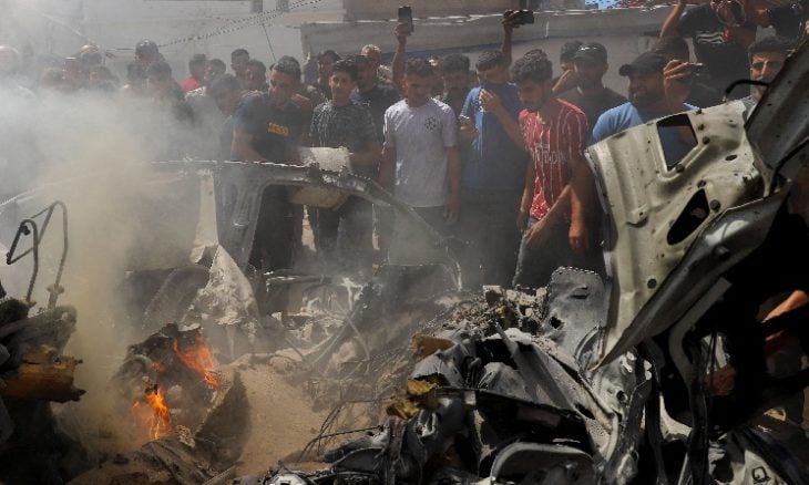 فلسطينيون يتفقدون موقع غارة إسرائيلية استهدفت مركبة في مدينة غزة، 9 يوليو 2026